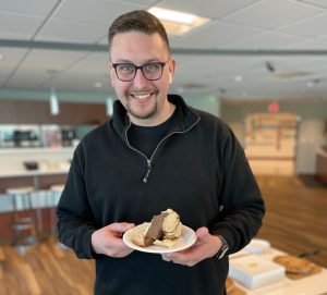 COCC employee holding a piece of pie during Pi Day 2022