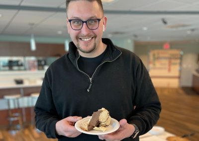 COCC employee holding a piece of pie during Pi Day 2022